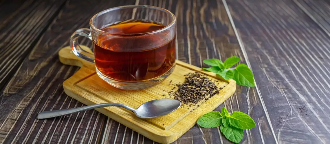 A cup of herbal tea with fresh medicinal herbs for digestion